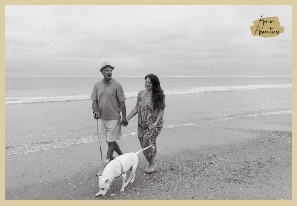 how to make old dog comfortable- couple and dog walking on beach